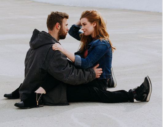 A man and woman sitting on the ground