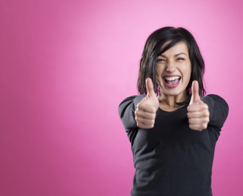 Excited girl giving thumbs up to show happiness