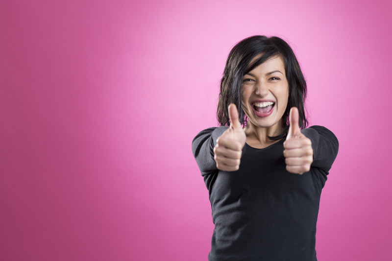Excited girl giving thumbs up to show happiness