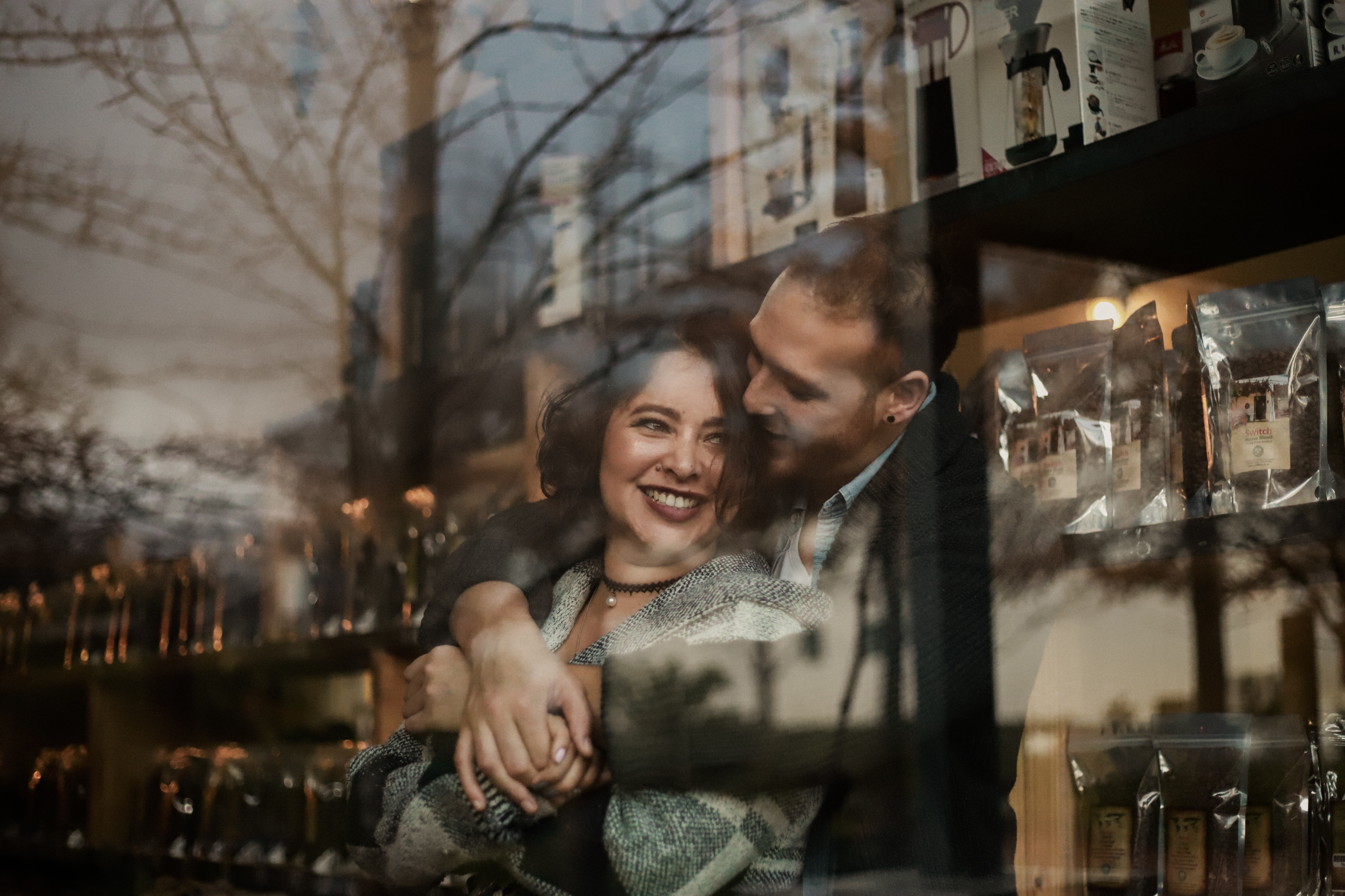 A man and woman hugging in front of a building.