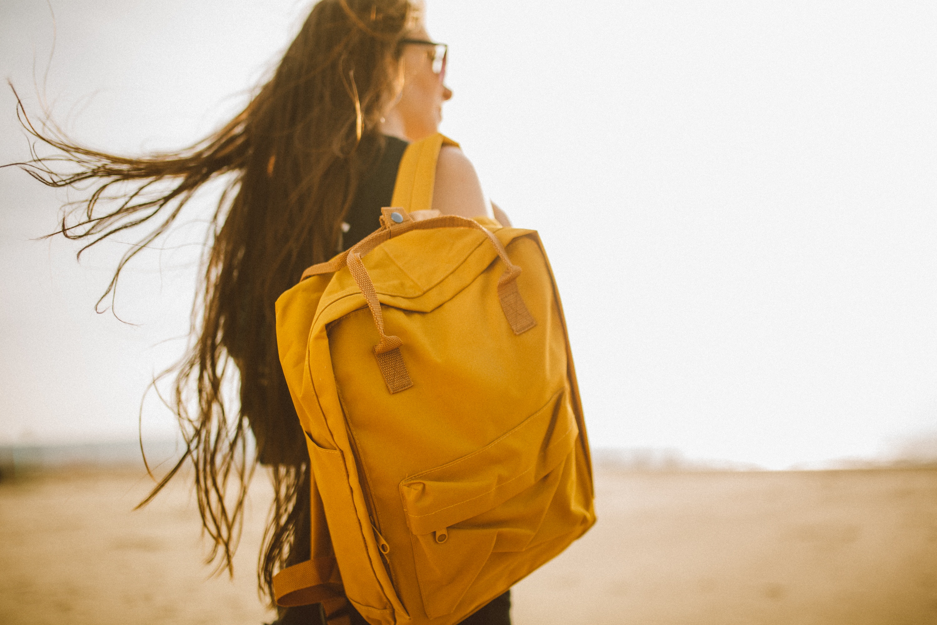 A woman with long hair holding onto a yellow bag