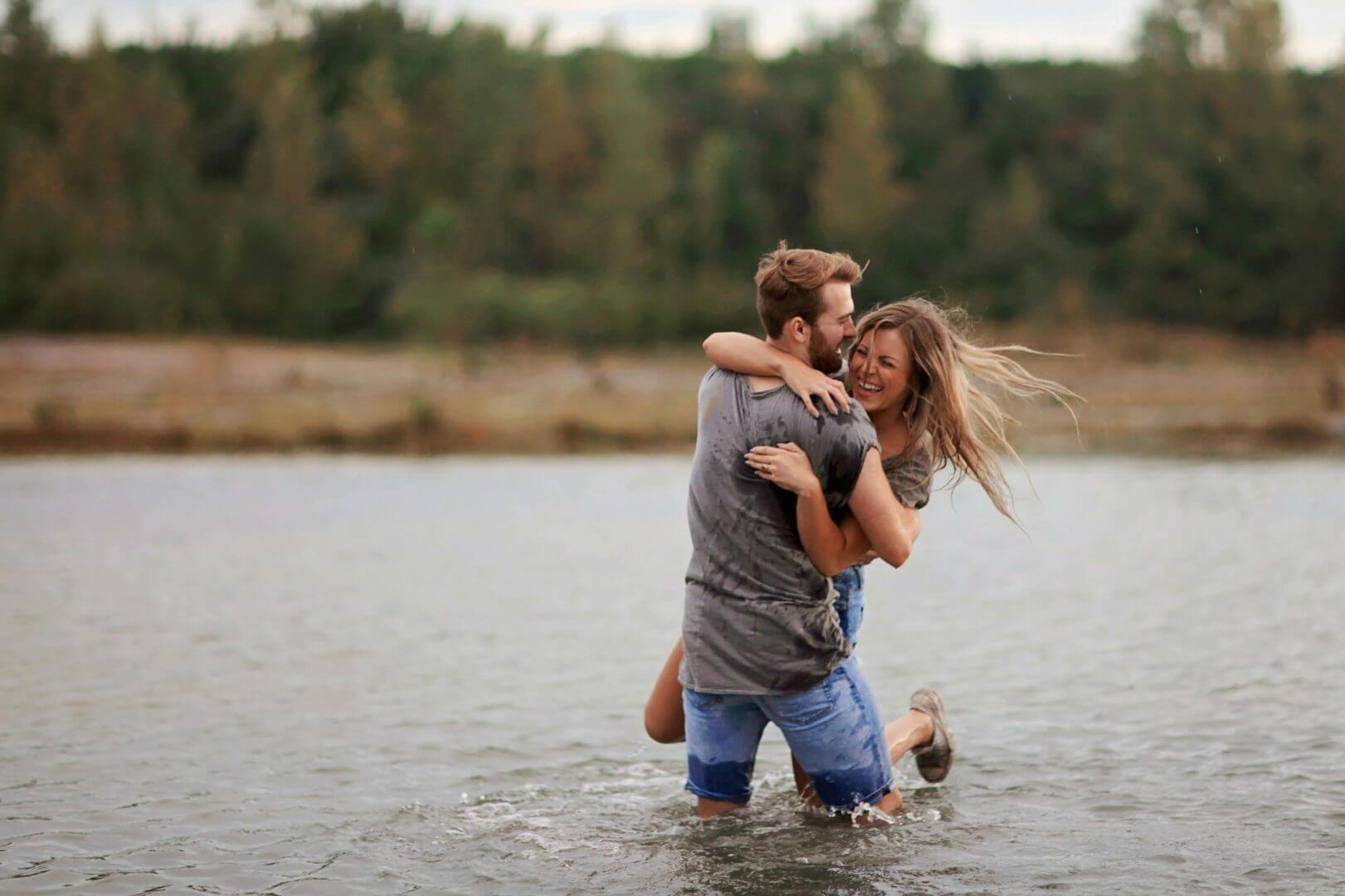 A man and woman are hugging in the water.